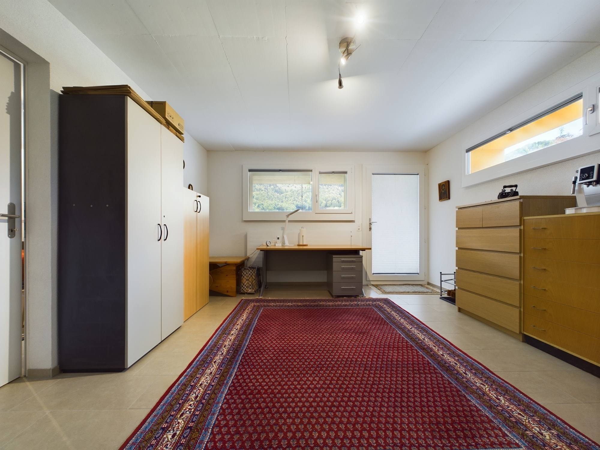 Helles Arbeits- bzw. Schlafzimmer mit Schränken und Schreibtisch