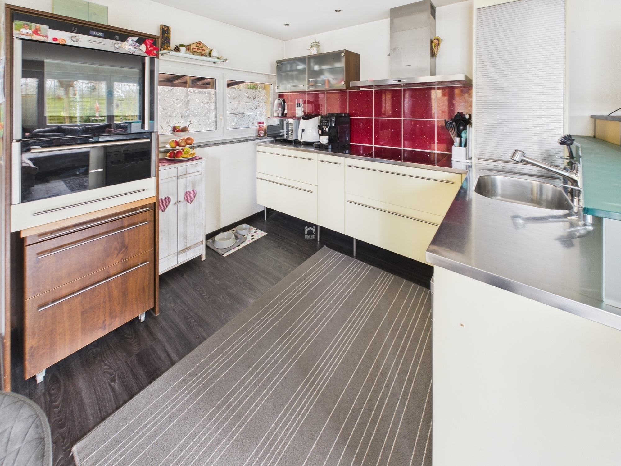 Moderne Küche mit dunklem Boden und roten Fliesen