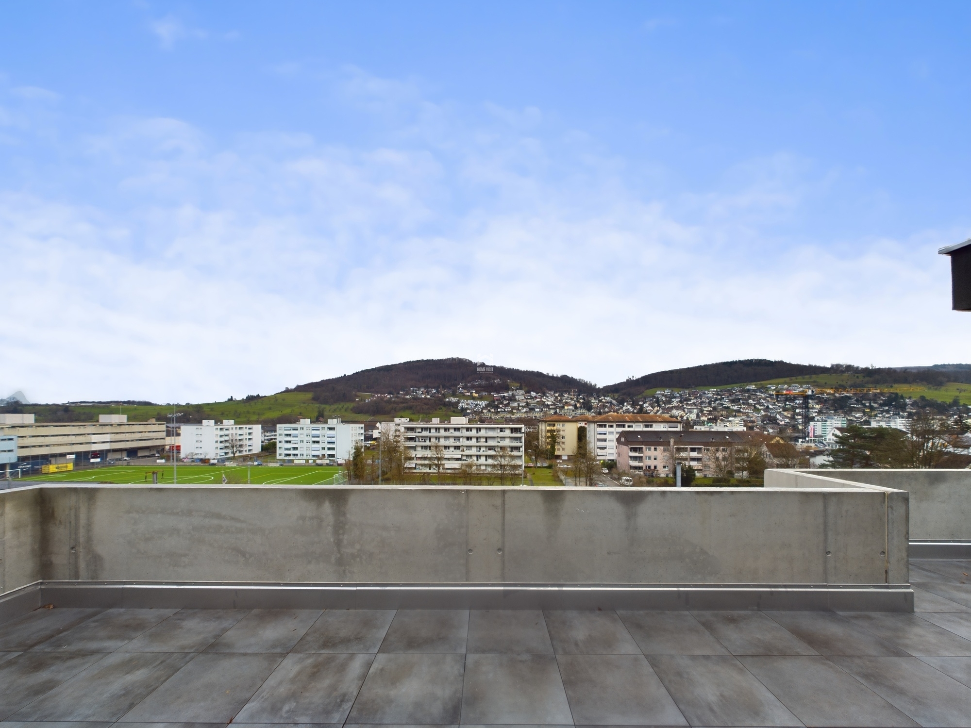 Dachterrasse mit Ausblick auf Stadt und Hügel