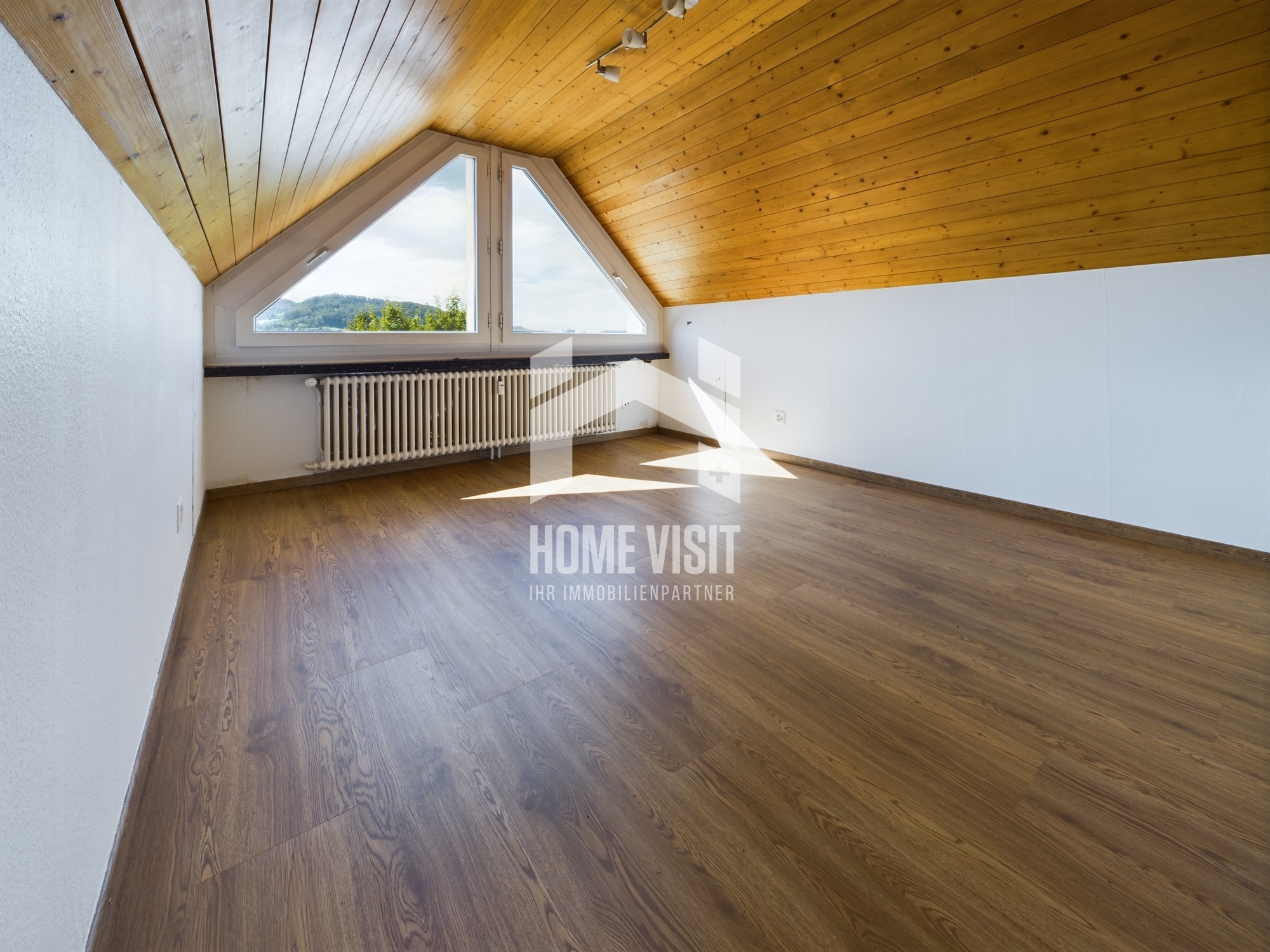 Leerer Dachraum mit Holzdecke und Giebelfenster