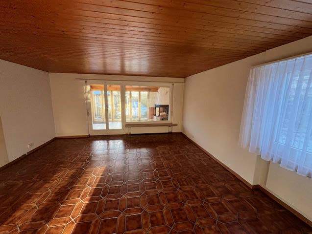 Leerer Wohnraum mit Holzdecke und Fliesenboden