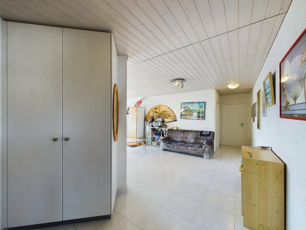 Heller Wohnraum mit Fliesenboden und viel Wanddekor