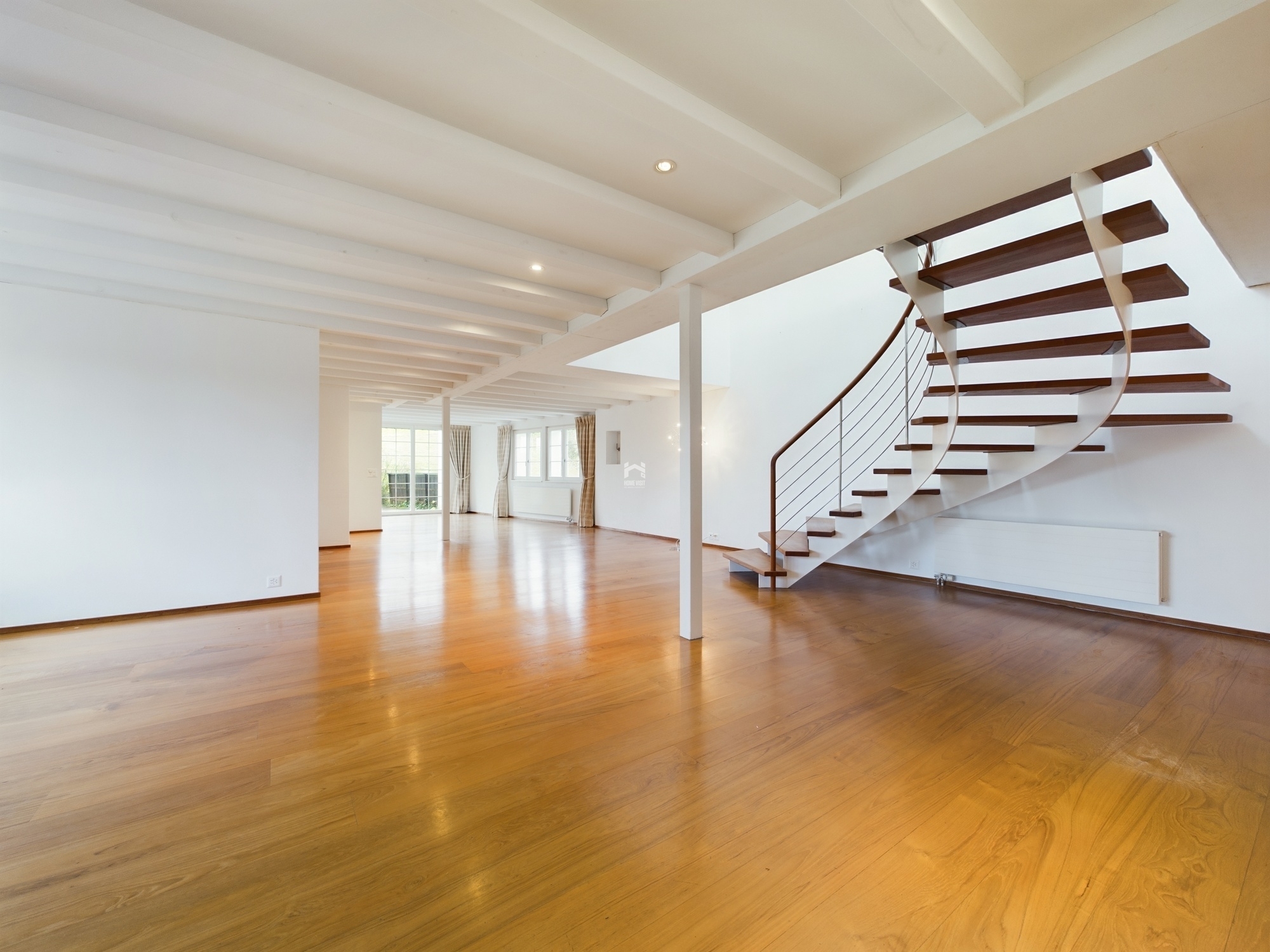 Großer, heller Wohnraum mit offener Treppe