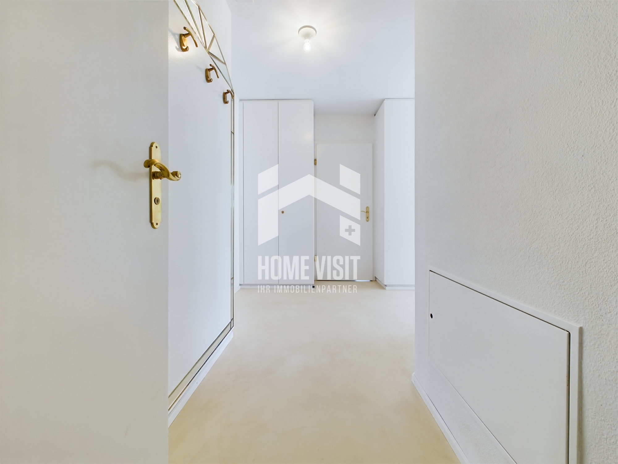 Heller Flur mit weißen Türen und goldenen Beschlägen