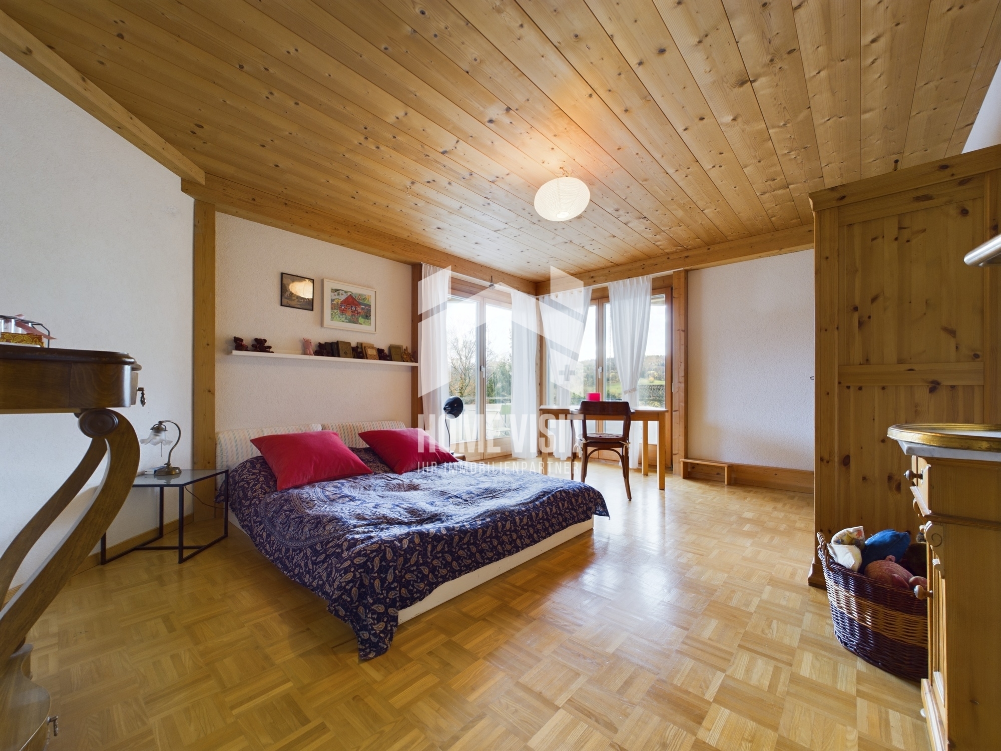 Helles Schlafzimmer mit Holzdecke und Balkonfenster
