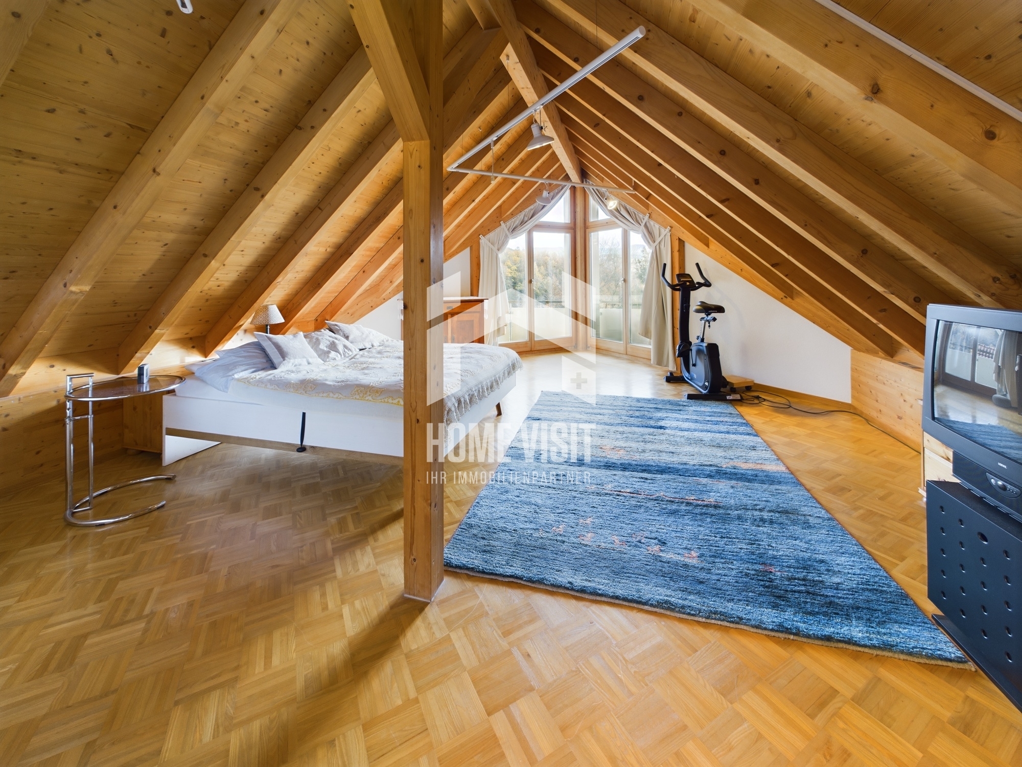 Dachgeschoss-Schlafzimmer mit sichtbarem Holztragwerk