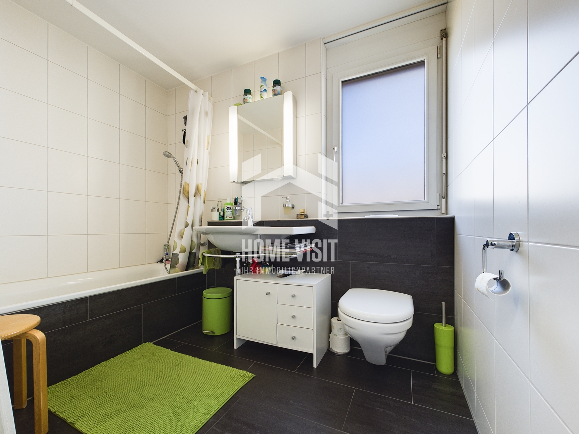 Modernes Badezimmer mit dunklen Bodenfliesen und weißer Ausstattung