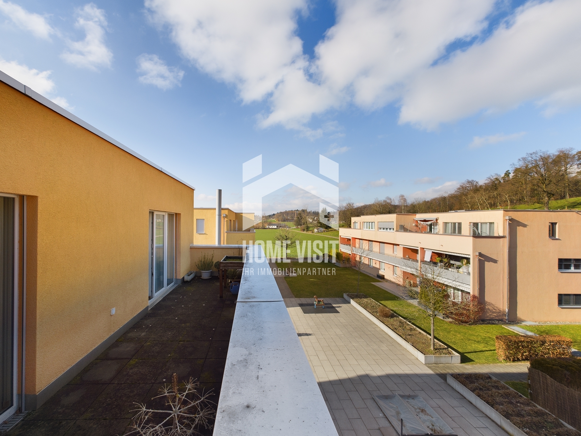 Dachterrasse mit Ausblick auf Wohnanlage und Landschaft