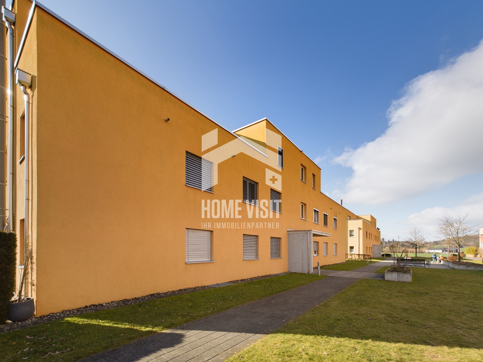 Außenansicht eines modernen Wohngebäudes mit Gartenweg