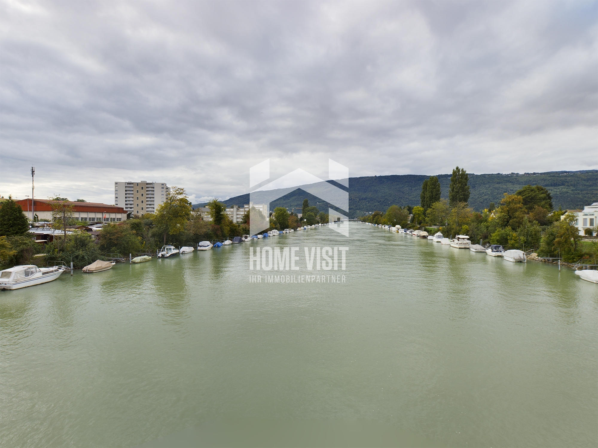 Blick über einen Flusskanal mit Bootsanlegern und Uferbebauung