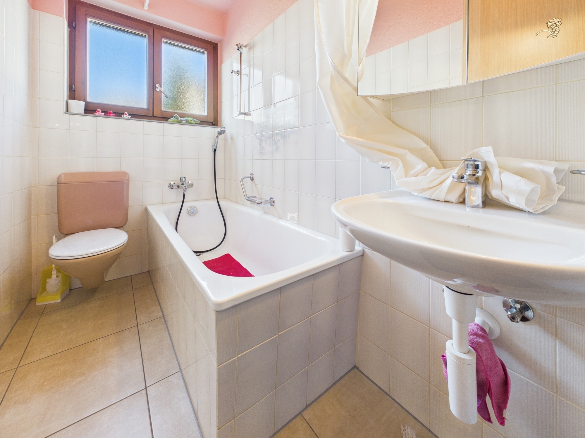 Kleines Badezimmer mit Badewanne und Fenster