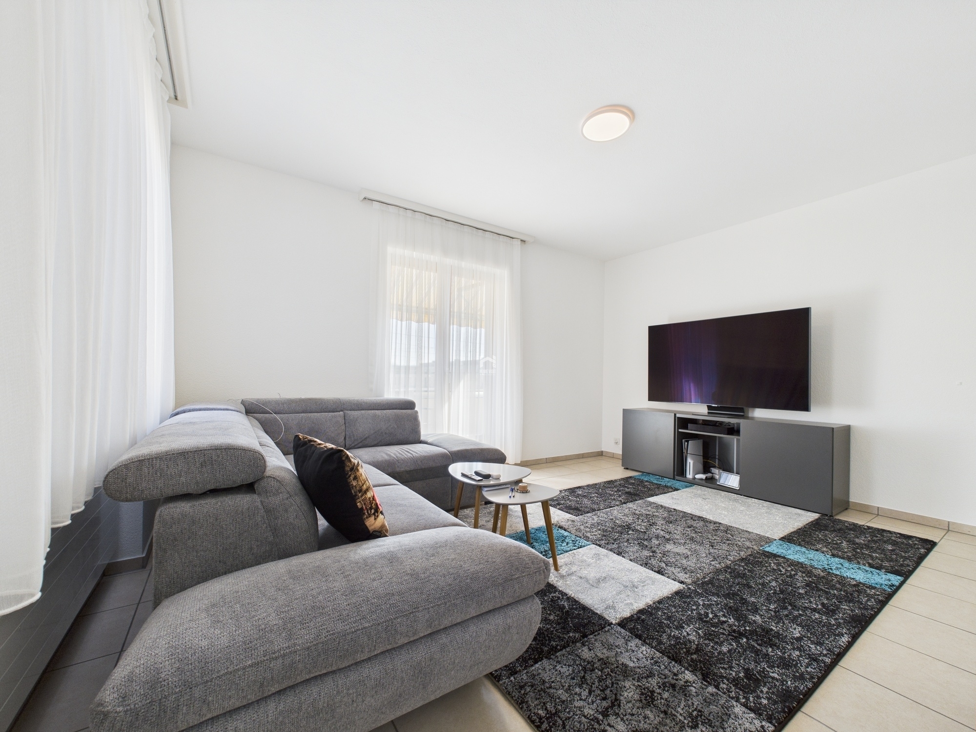 Helles modernes Wohnzimmer mit Ecksofa und TV