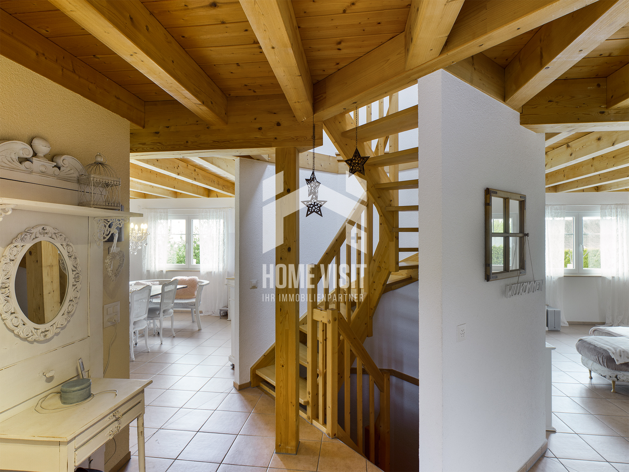 Helle Wohnszene mit Holztreppe und sichtbaren Dachbalken