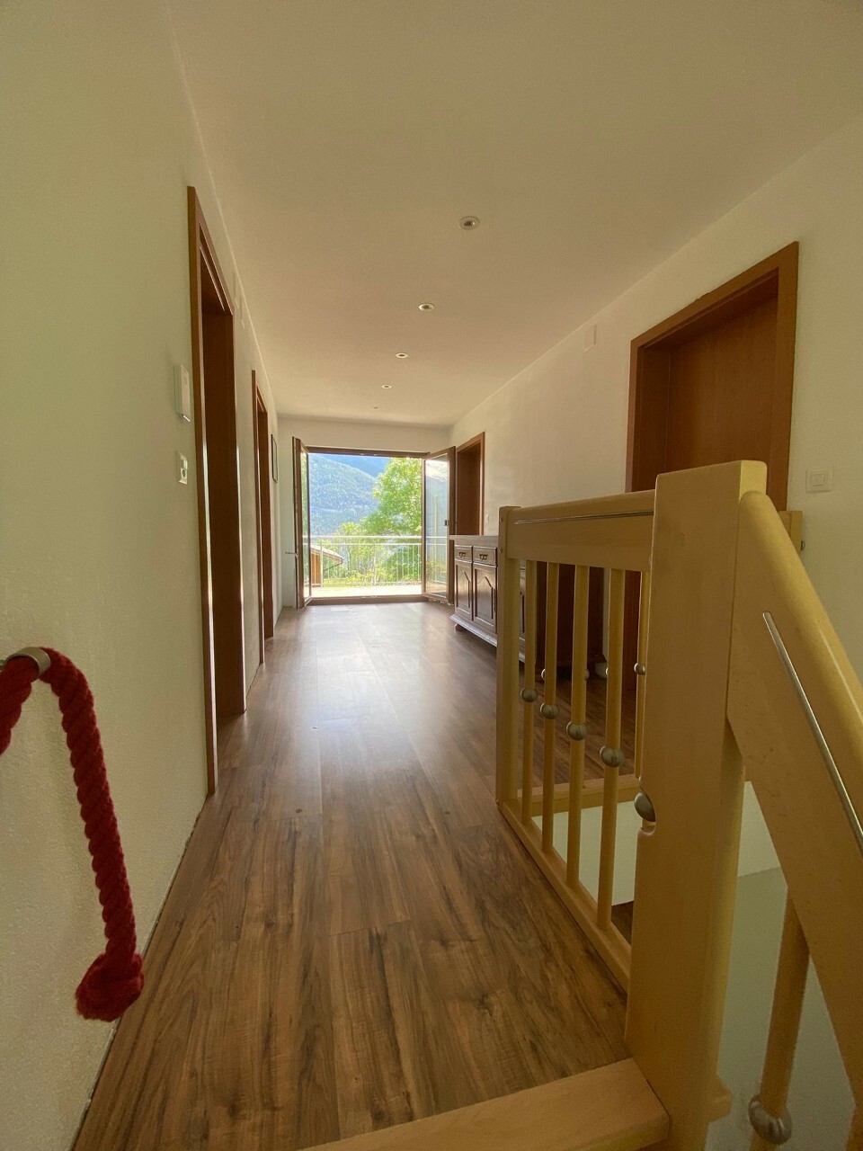 Langer Flur mit Treppe und Balkonblick