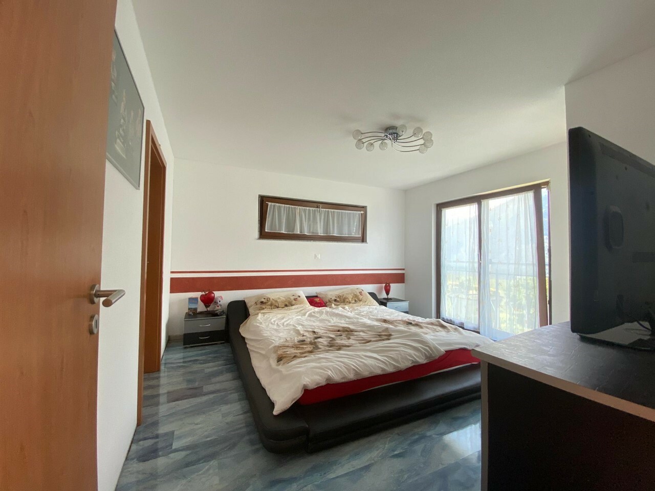 Schlafzimmer mit Bett und Balkonfenster