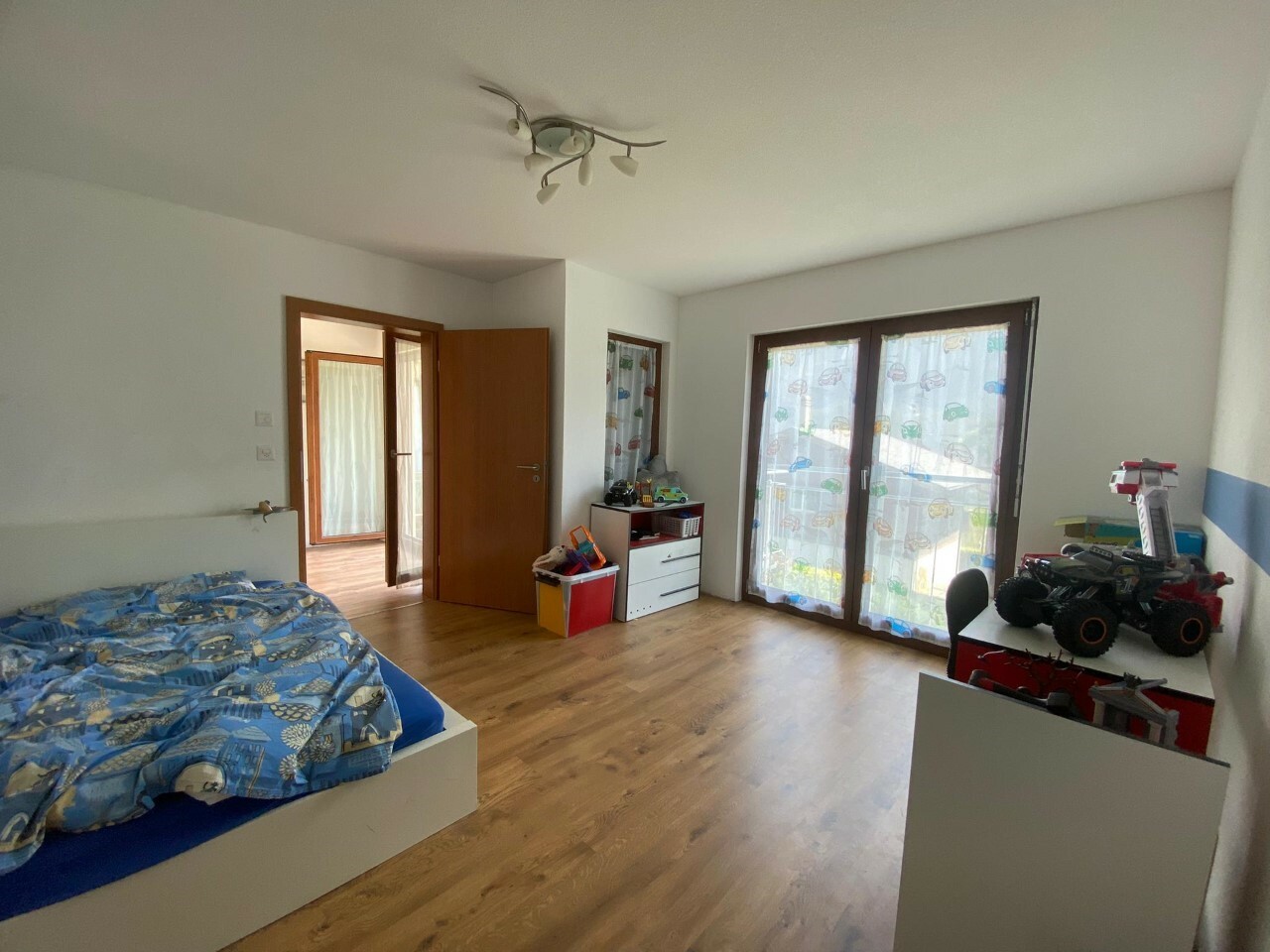 Kinderzimmer mit Bett und Balkon-/Terrassentüren