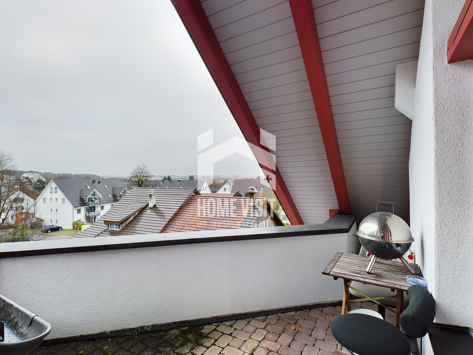 Balkon mit Grill und Ausblick über Wohnhäuser