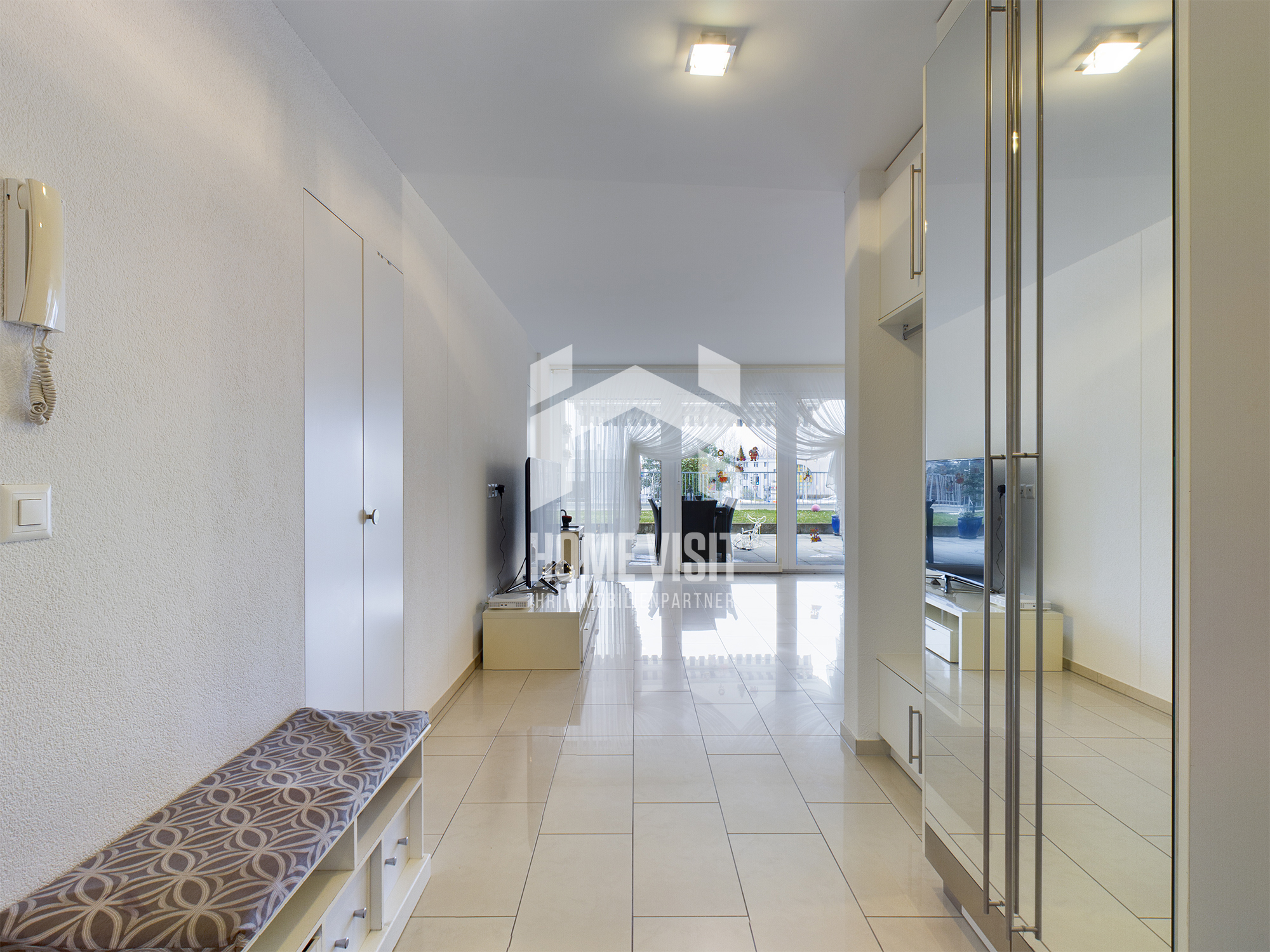 Heller Flur mit Einbauschränken und Blick ins Wohn-/Esszimmer