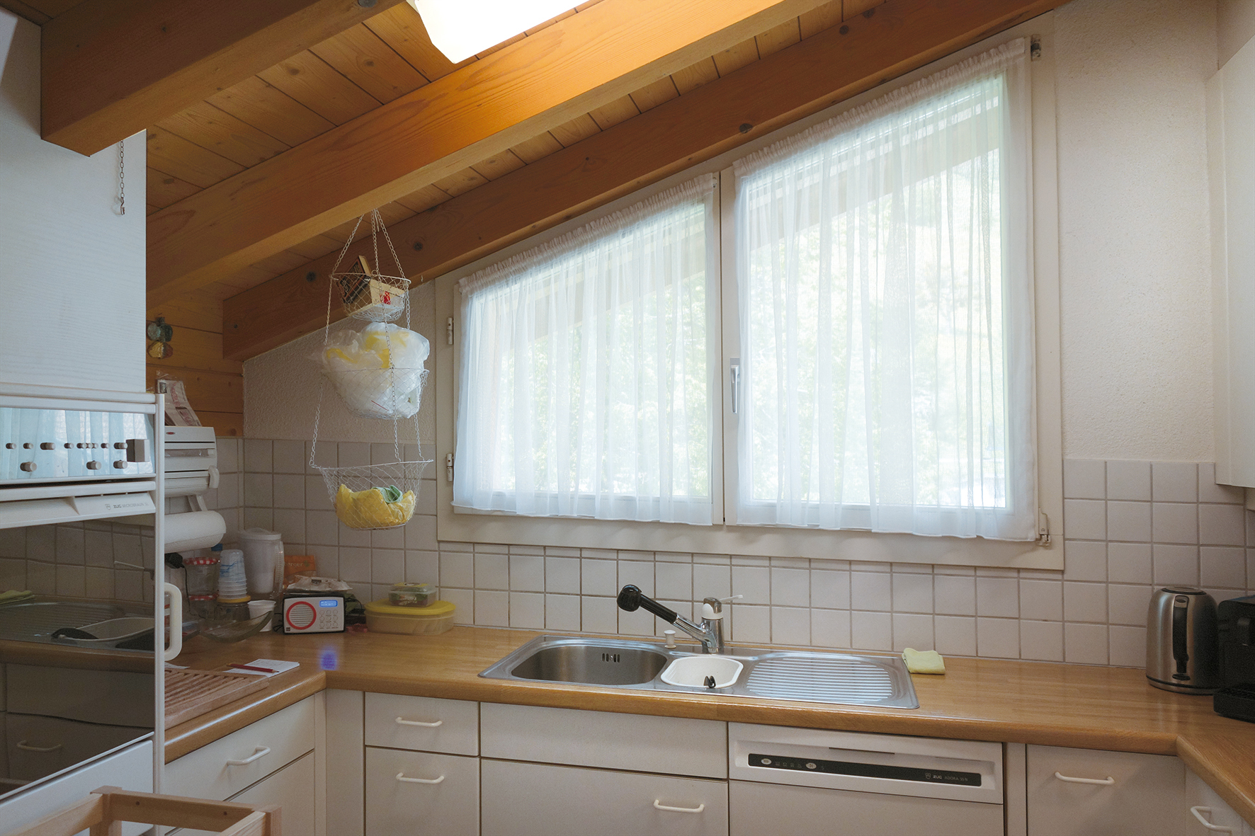 Kleine Küche mit Holzdecke und Fensterfront