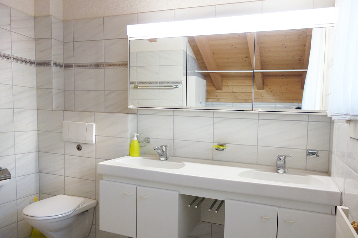 Helles Badezimmer mit Doppelwaschtisch und Dachschräge