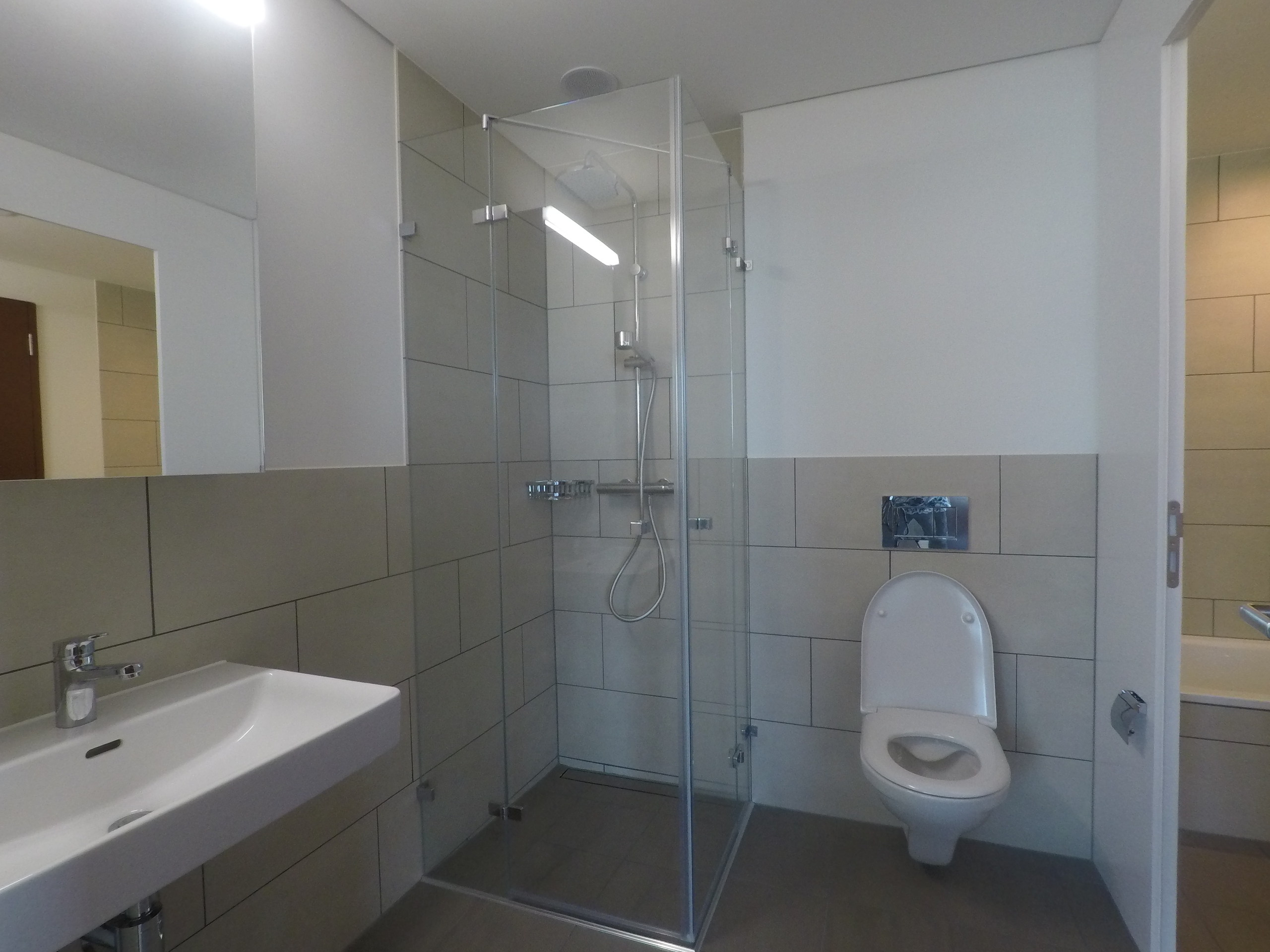 Modernes Badezimmer mit Glasdusche und wandhängendem WC