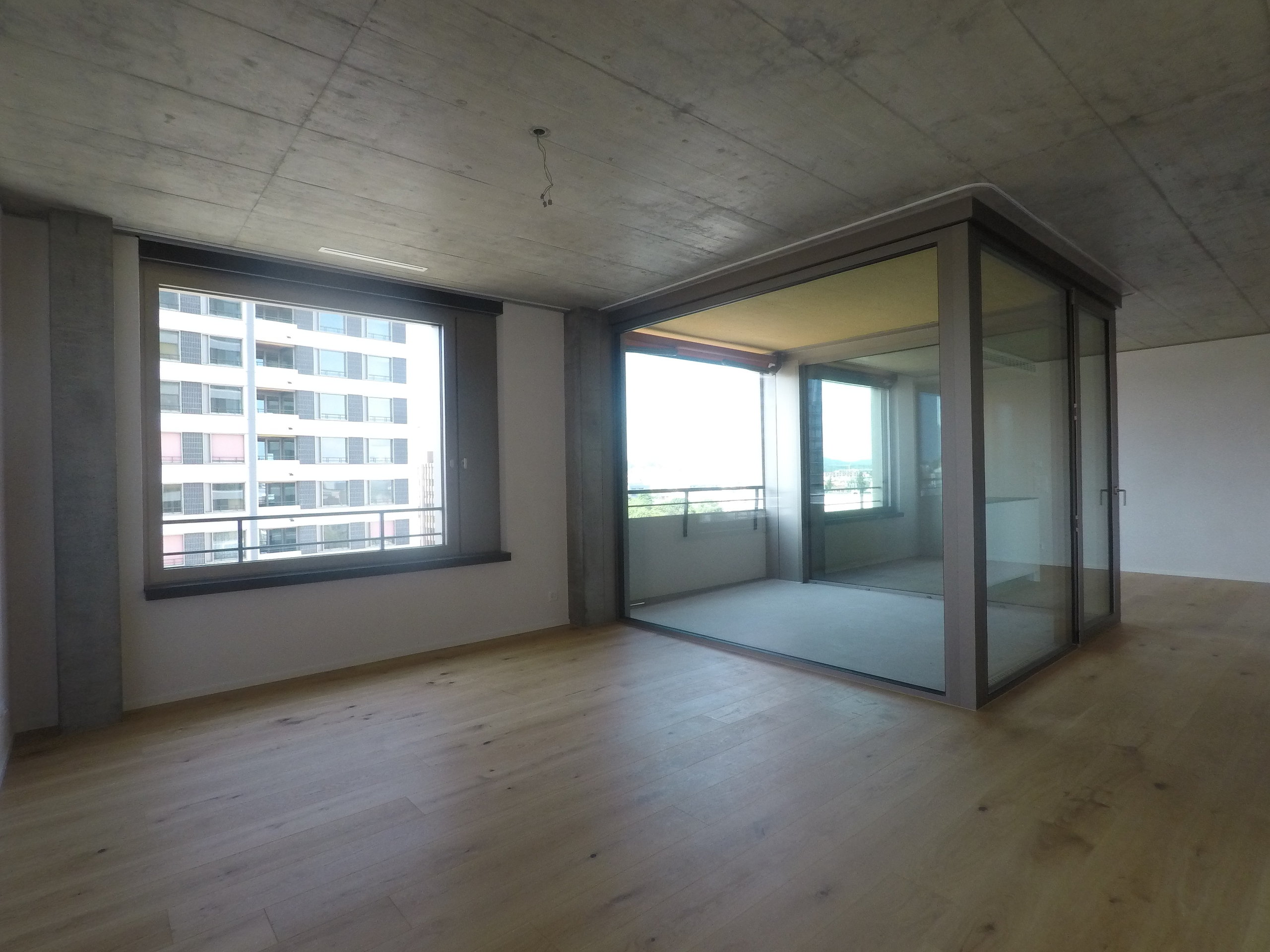 Großer leerer Wohnraum mit Loggia und Stadtblick