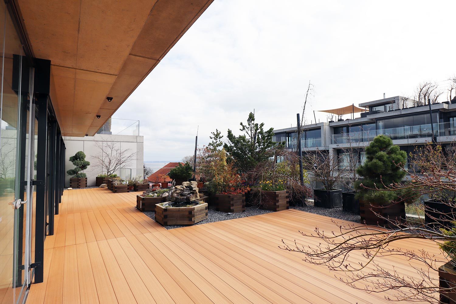 Moderne Dachterrasse mit Holzdeck und Pflanzgefäßen