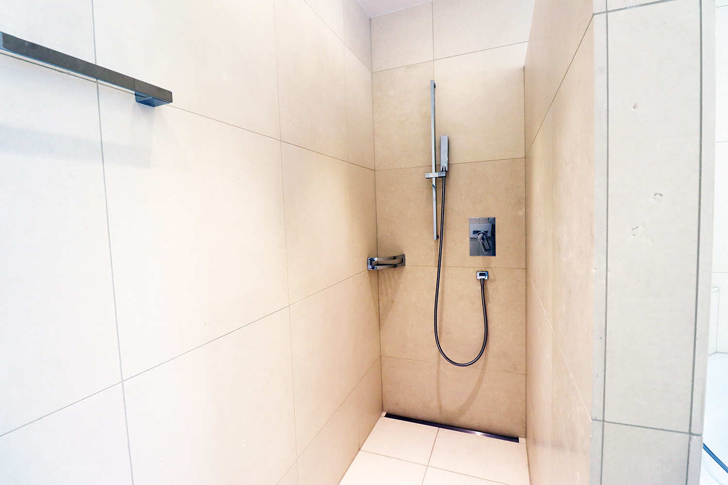 Begehbare Dusche in hellem Naturstein-Look