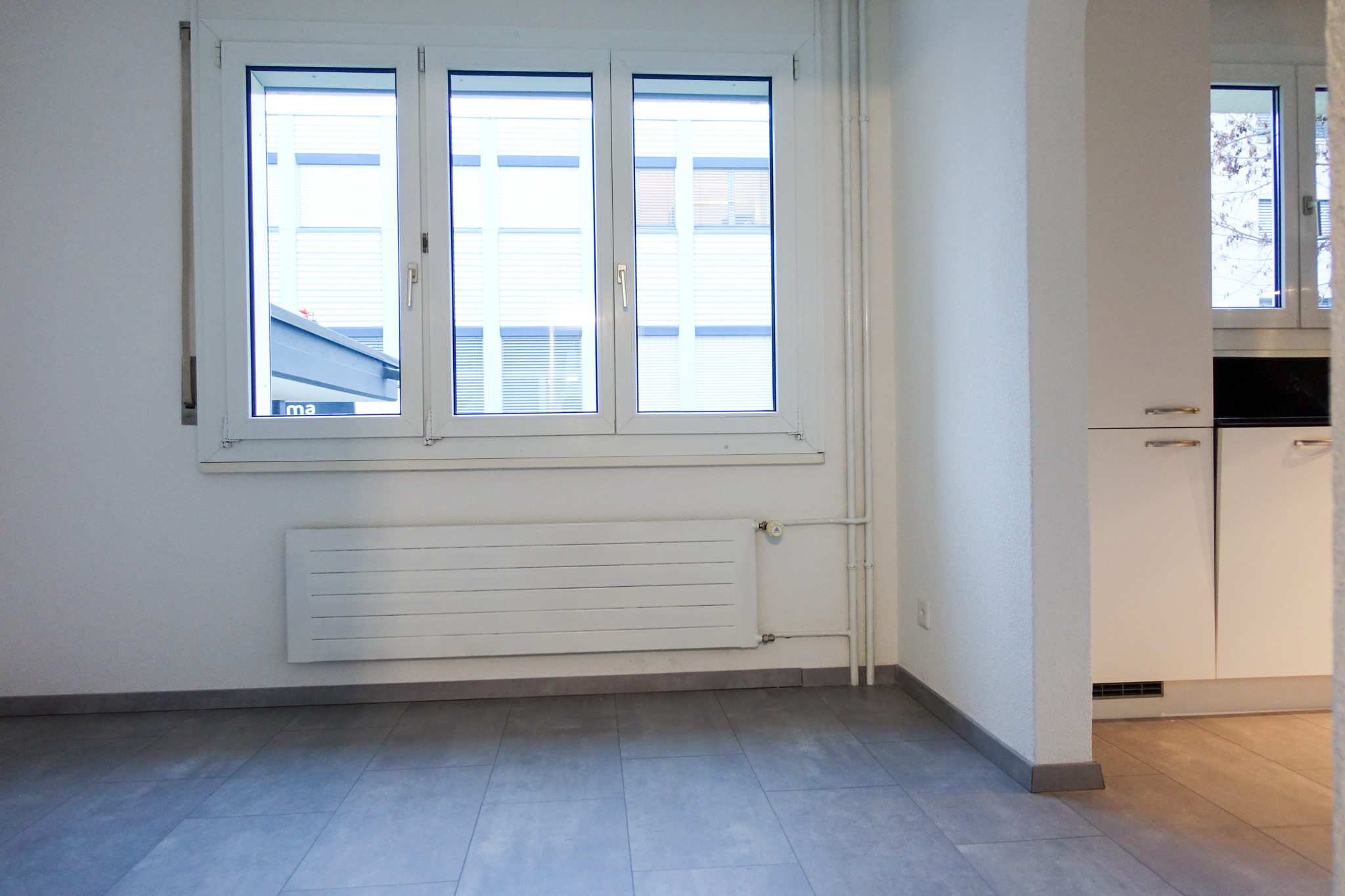 Heller leerer Innenraum mit Fensterfront und Heizkörper