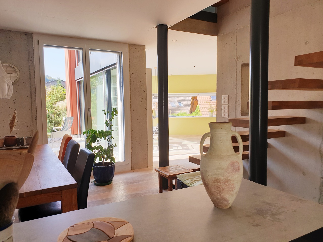Offener Wohnbereich mit Treppe und Terrasse