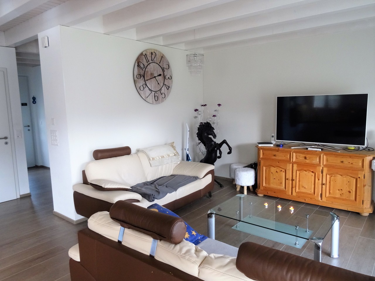Wohnzimmer mit TV und Sofalandschaft