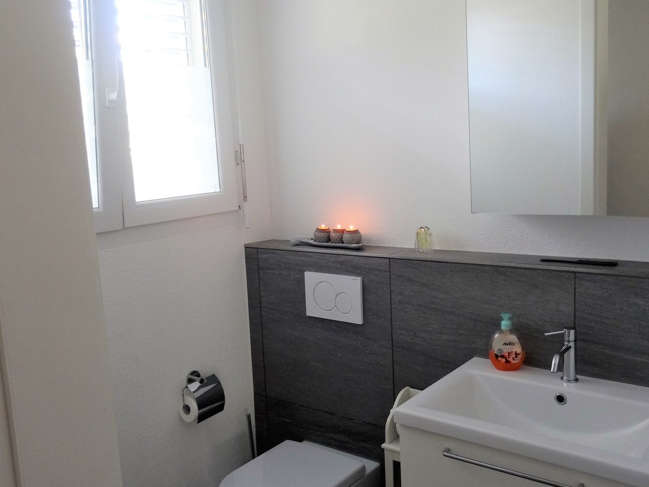 Modernes Gäste-WC mit dunklem Waschtischunterschrank