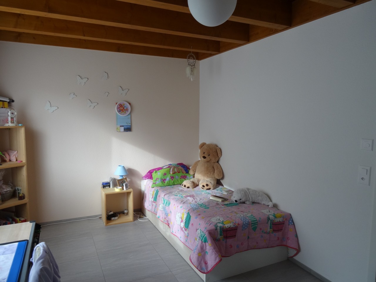 Kinderzimmer mit Einzelbett und Holzregal