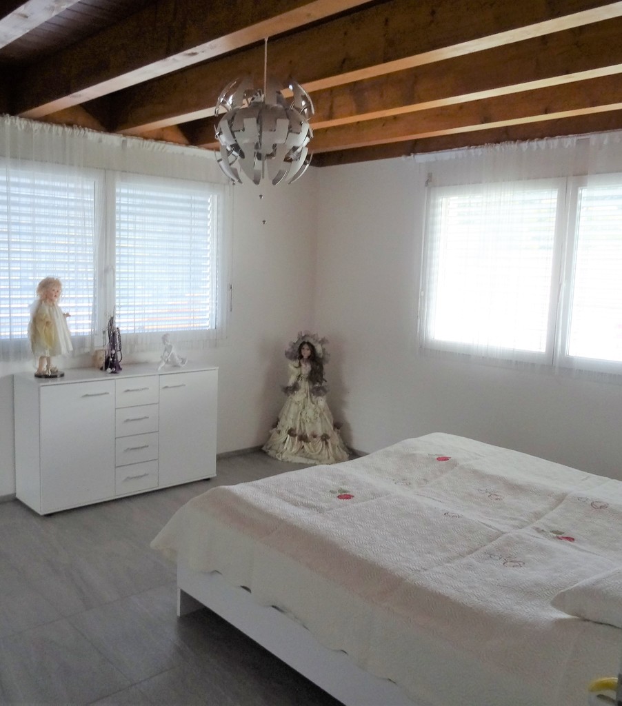 Helles Schlafzimmer mit sichtbaren Holzbalken
