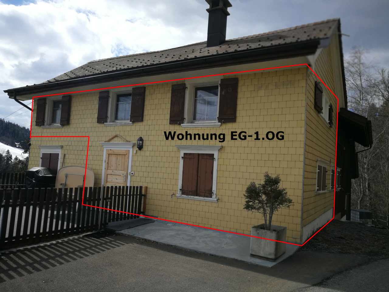 Gelbes Wohnhaus mit Schrägdach und Fensterläden
