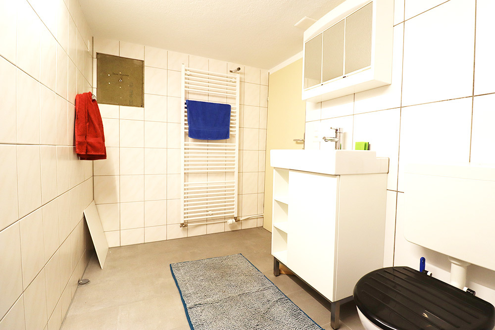 Helles Badezimmer mit Sanitärmöbeln und Wandheizkörper