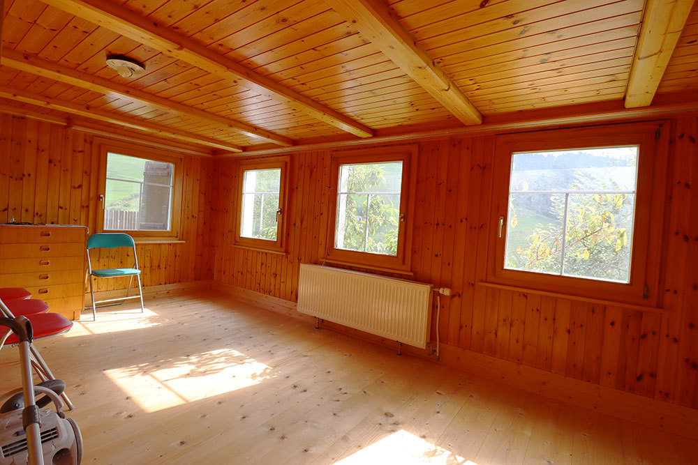 Holzverkleideter heller Raum mit Fenstern