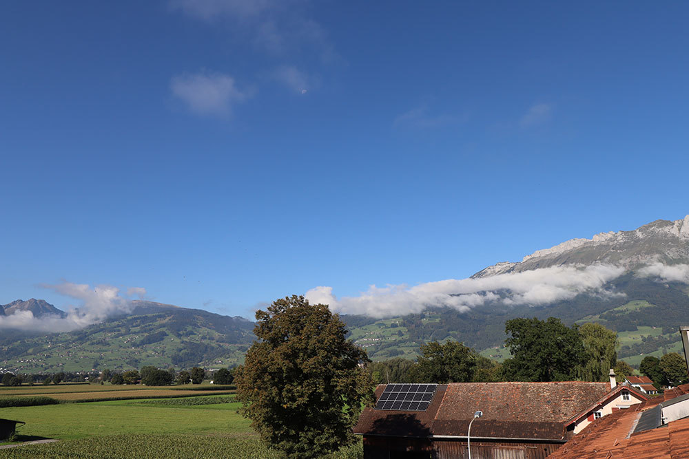 Alpenblick über Dächer und Solarpanel
