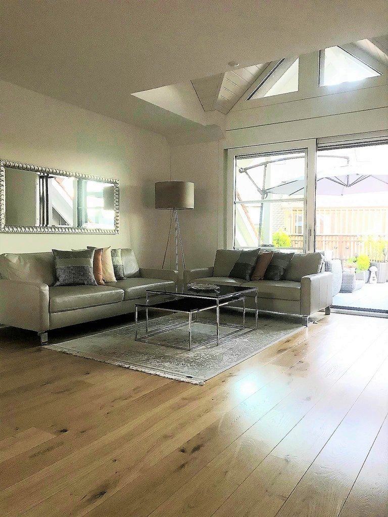 Heller Wohnraum mit Sofas und Zugang zur Terrasse