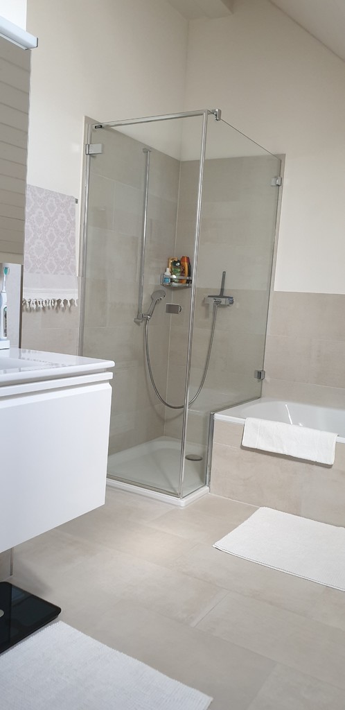 Modernes Badezimmer mit Glasdusche und Wanne