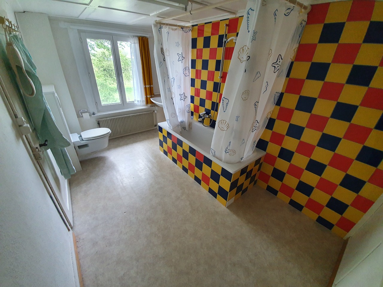 Badezimmer mit farbenfroher Fliesenwand