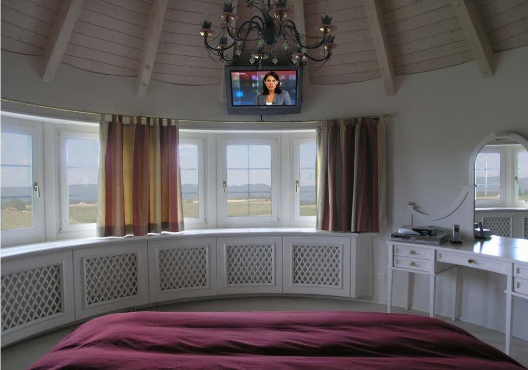 Schlafzimmer mit Rundfenster und Blick ins Freie