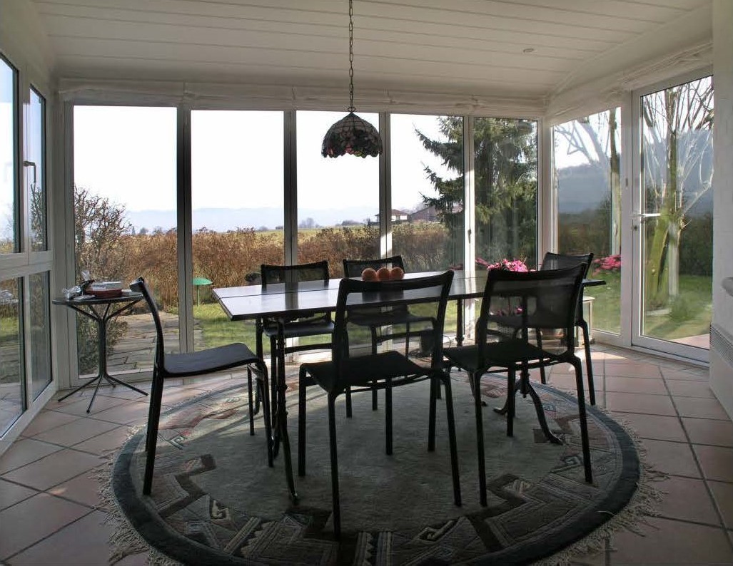 Verglaster Essbereich mit Gartenblick