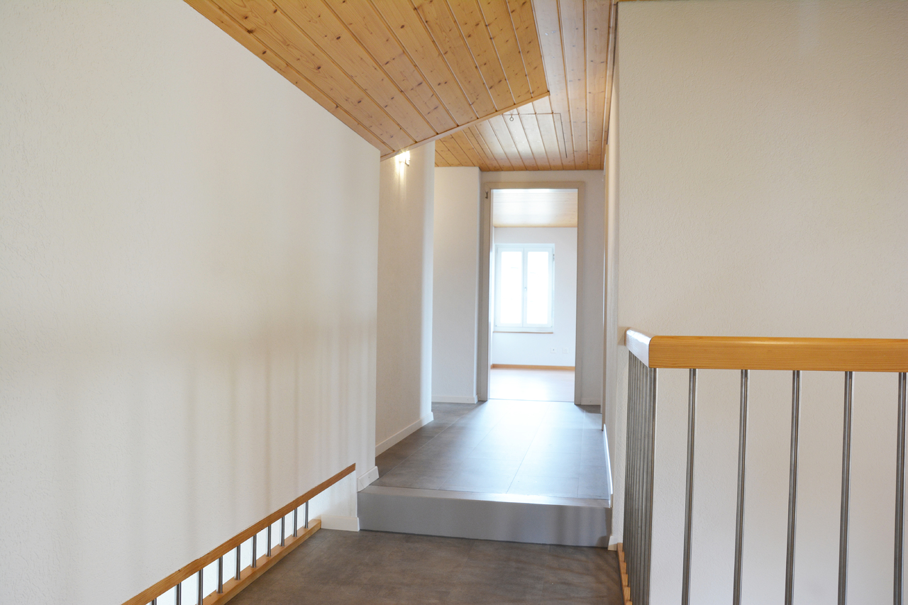 Heller Flur mit Treppe und Holzdecke