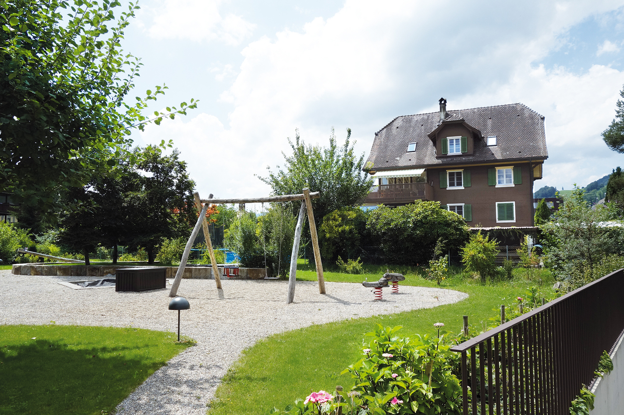 Außenansicht eines Hauses mit Garten und Spielbereich