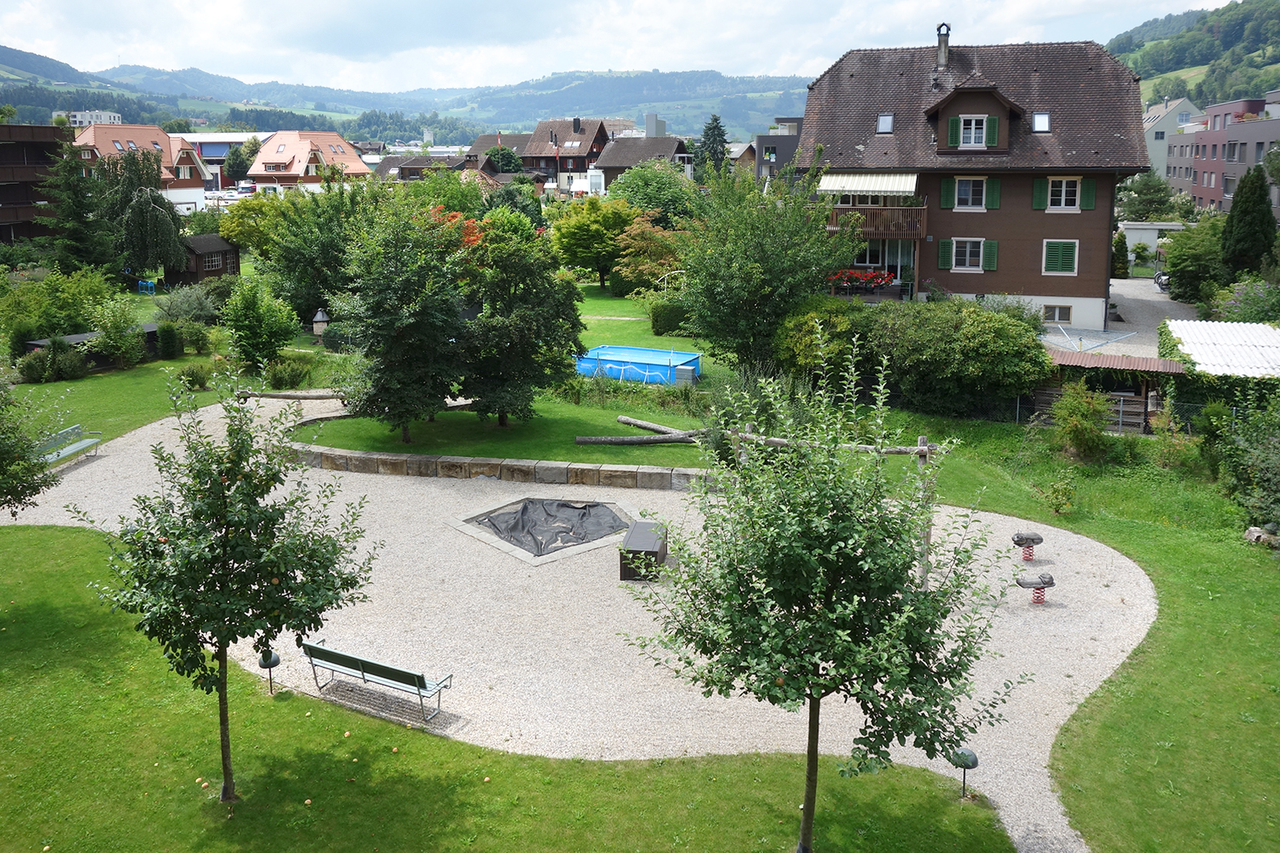Gartenansicht mit Wohnhaus und Grünfläche