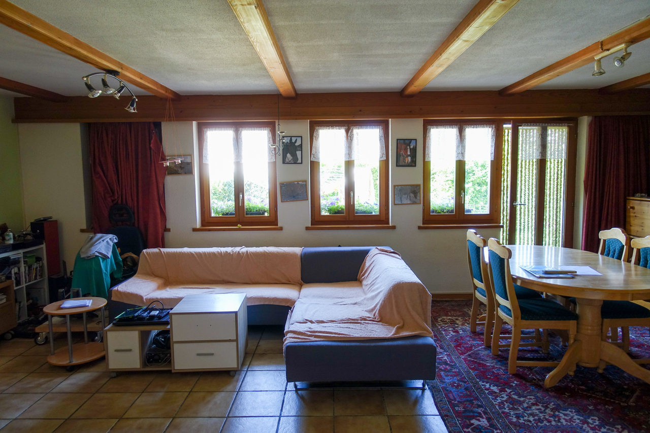 Wohn- und Esszimmer mit großen Holzfenstern