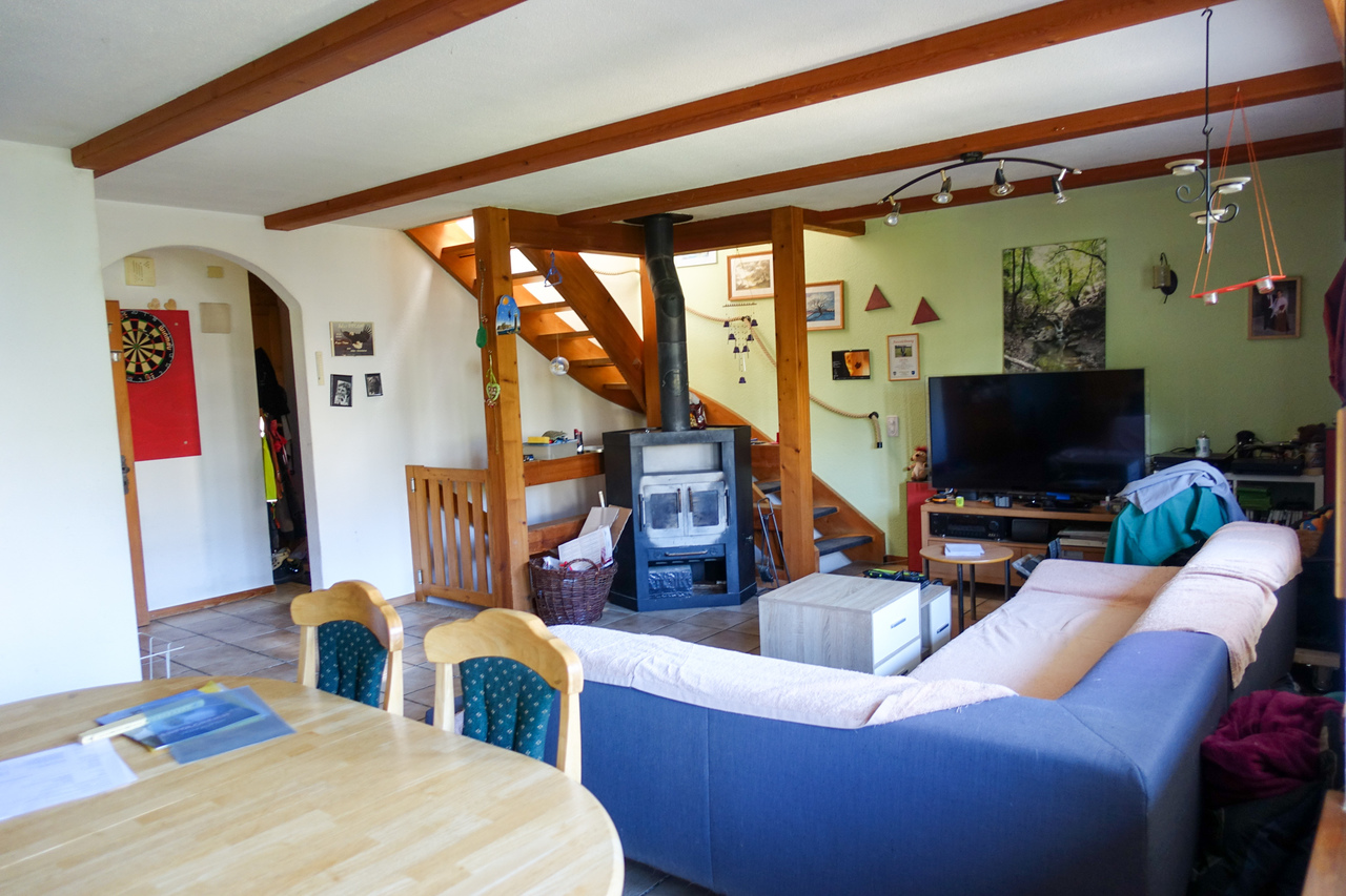 Gemütliches Wohnzimmer mit Kamin und Treppe