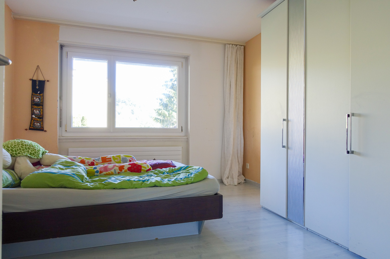 Schlafzimmer mit großem Fenster und Einbauschrank