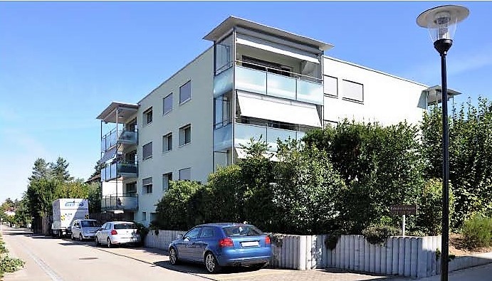 Mehrfamilienhaus mit Balkonen an einer Straße